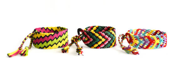 istock Woven DIY friendship bracelets with bright colorful pattern handmade of thread on white background 1305776551