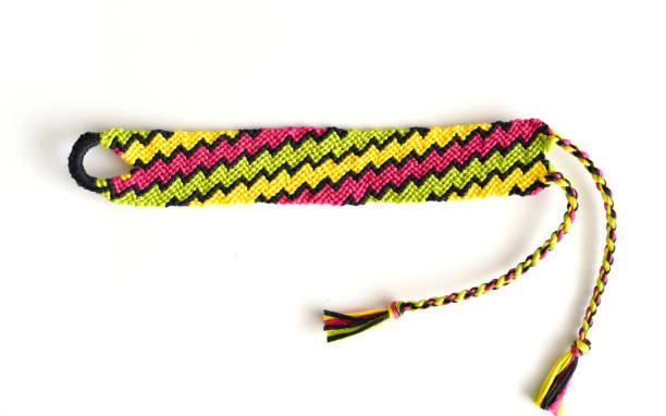 istock Woven DIY friendship bracelet with bright colorful pattern handmade of thread on white background 1305776552