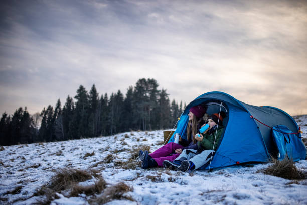Kids enjoying camping in tent on the hill