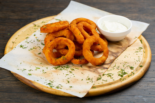 deep-fried onion rings in breading with creamy sauce. beer snack.