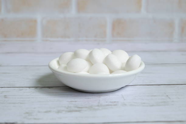 istock White naphthalene balls on white wooden background 1305781763