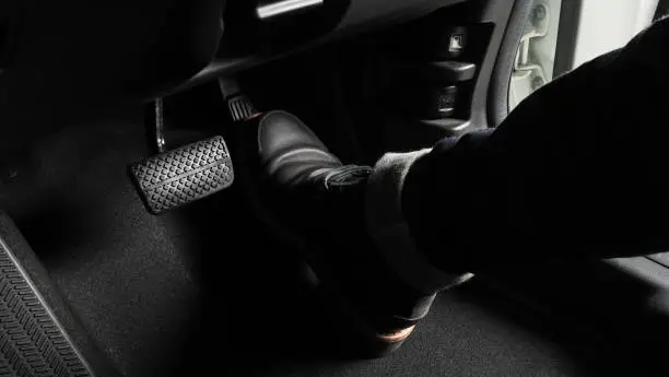 Photo of Accelerator and breaking pedal in a car. Close up the foot pressing foot pedal of a car to drive ahead. Driver driving the car by pushing accelerator pedals of the car. inside vehicle.
