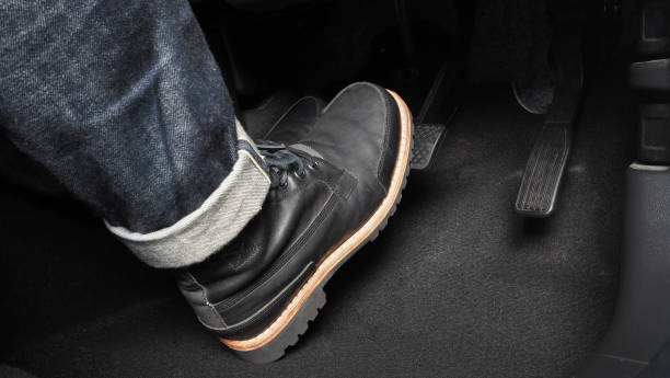 accelerator and breaking pedal in a car. close up the foot pressing foot pedal of a car to drive ahead. driver driving the car by pushing accelerator pedals of the car. inside vehicle. - travão imagens e fotografias de stock