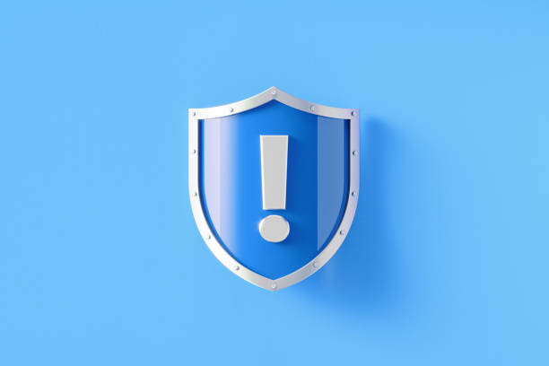 Silver shield with exclamation point sitting on blue background, Horizontal composition with copy space. Warning and alertness concept.