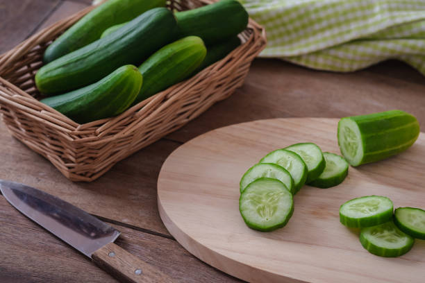 istock Cucumber sliced on wooden cutting board 1305785895