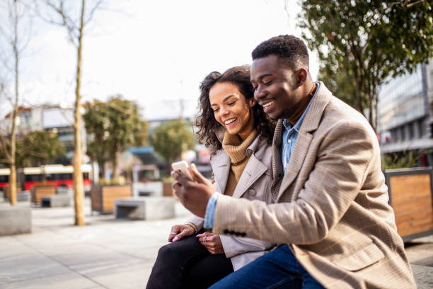 istock Happy young couple using phone outdoors in the city. 1305786090