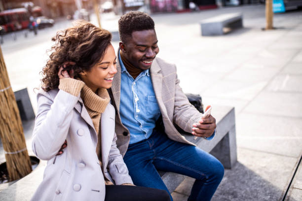 istock Happy young couple using phone outdoors in the city. 1305786099