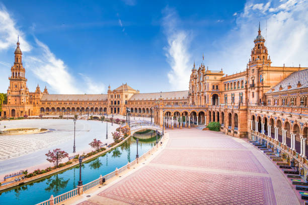 plaza de españa en sevilla, españa. un gran ejemplo de la arquitectura renacentista ibérica durante una jornada de verano con cielo azul - sevilla fotografías e imágenes de stock