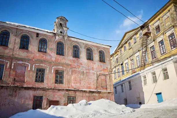 Old crumbling abandoned buildings in a forgotten area of the city. Winter landscape.