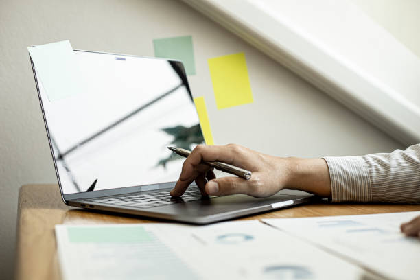 A close-up photo of a businessman typing on a laptop keyboard to examine the company's financial documents prepared by the Finance Department for a meeting with a business partner. Financial concept. una foto de primer plano de un hombre de negocios escribiendo en un teclado portátil para examinar los documentos financieros de la compañía preparados por el departamento de finanzas para una reunión con un socio comercial. concepto financiero.