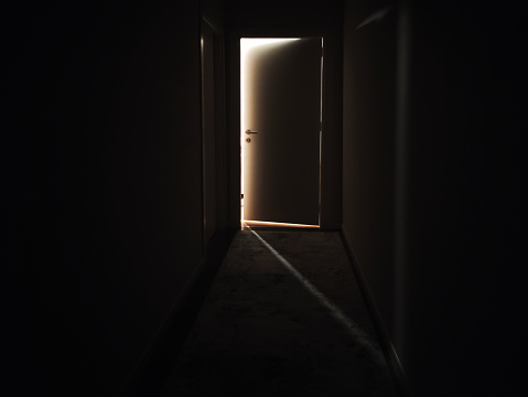 Door to the light in a dark corridor