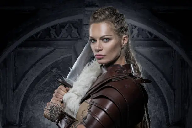 Beautiful Blonde weapon wielding viking warrior female in studio shot