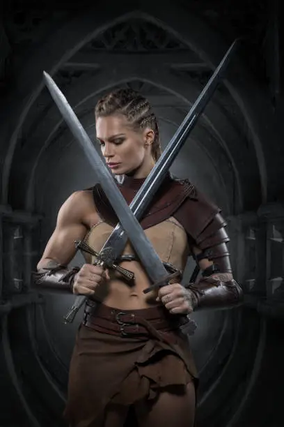 Beautiful Blonde weapon wielding viking warrior female in studio shot