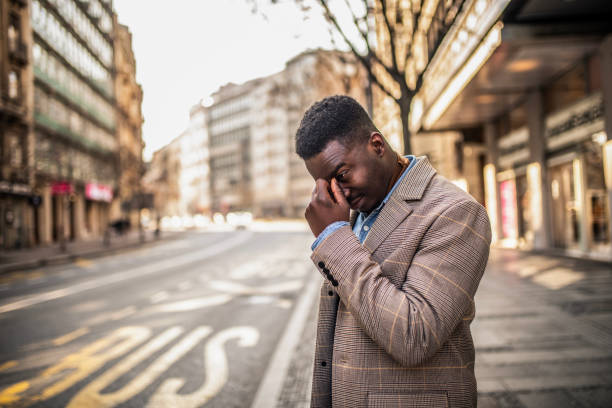 istock Young man standing on city street having headache. 1305797036