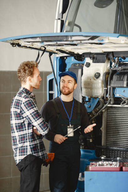 istock Two men repairing a truck with a tools 1305797077
