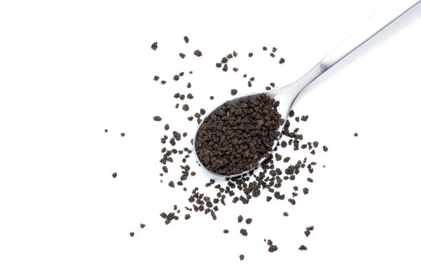 istock black tea granules isolated on white background. design element. indian beverage tea on spoon cut out 1305798313