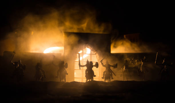 istock Medieval battle scene with cavalry and infantry. Silhouettes of figures as separate objects, fight between warriors on sunset foggy background. 1305805872