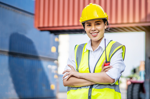 Portrait of asian female engineer wearing protection standing confidently crossed her arms in the cargo area of 