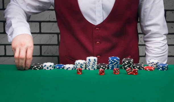 istock croupier, lays out chips and dice for the Board game blackjack 1305811198
