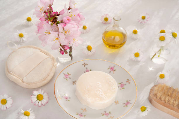 Homemade soap or shampoo with oil and flowers on the side