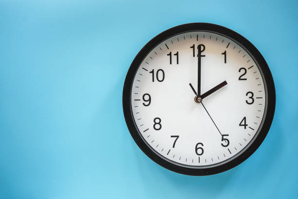 istock Classic black and white analog clock on blue background at Two o'clock with copy space 1305814584