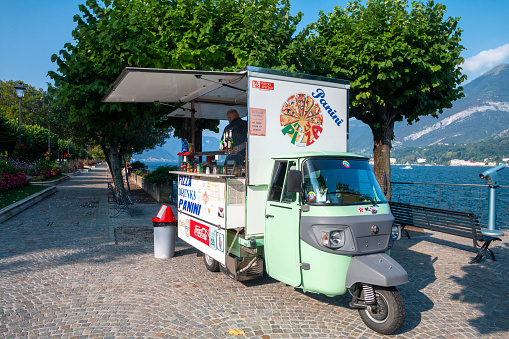 A man preparting food in the back of a Piaggio Food Truck in Bellagio on Lake Como, Italy