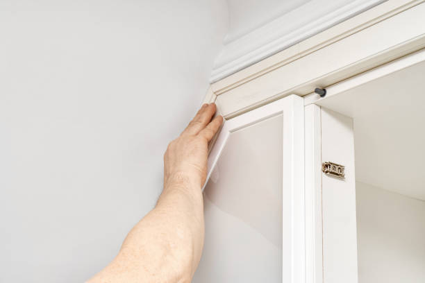 istock Man gluing wooden molding during wardrobe installation 1305816098
