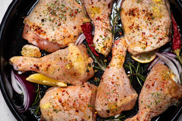 Raw uncooked chicken legs marinated with with spices and ingredients ready for cooking