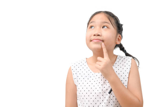 Cute Asian little girl thinking while looking to the copy space, isolated on white background. emotion concept