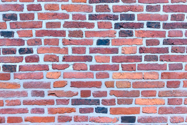 istock A wall of old, cracked bricks, with a weathered and faded surface. 1305819191