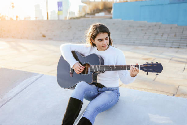 istock Beautiful young girl playing guitar 1305820543