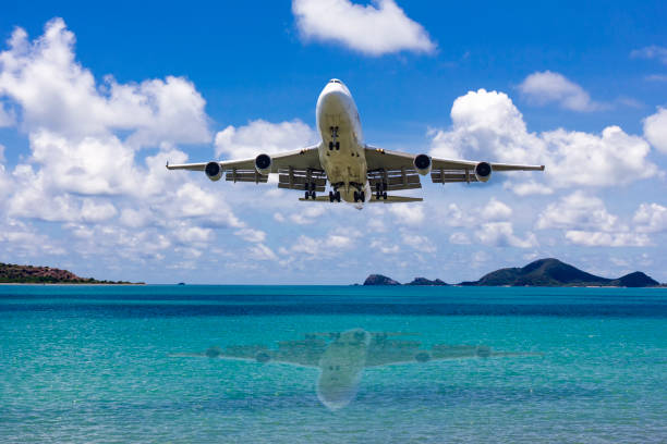 istock Front side view commercial passenger aircraft or cargo transportation airplane flying on blue sky over sea and spread the wheel prepare landing to airport in bright day 1305821865