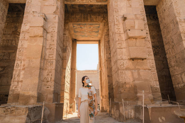 Woman walking in the ancient Egyptian temple in Luxor during Covid-19 pandemic Woman walking in the ancient Egyptian temple in Luxor during Covid-19 pandemic ancient civilization photos stock pictures, royalty-free photos & images