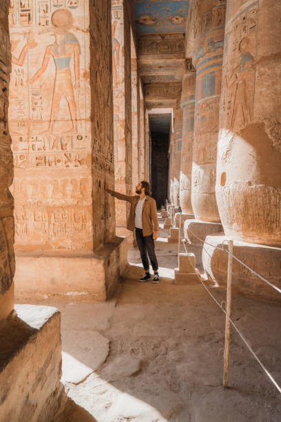 istock Man walking in the ancient Egyptian temple in Luxor 1305822884