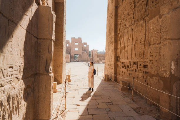 frau zu fuß in der alten ägyptischen tempel in luxor - journey elegance people traveling architecture stock-fotos und bilder