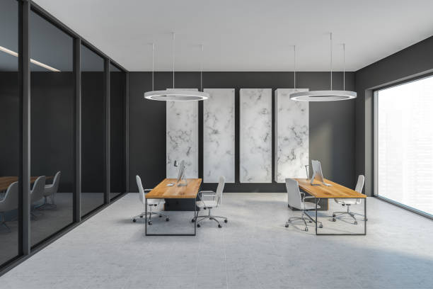 istock Grey office room with chairs and computer on wooden tables, tiled floor 1305822893