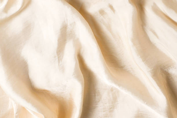 istock Soft smooth beige silk fabric background. Fabric texture. 1305823166