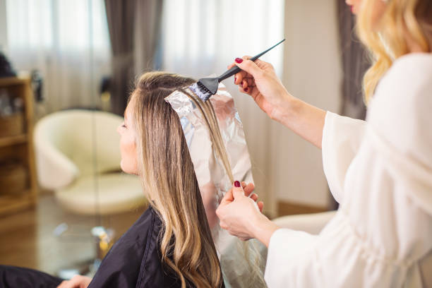 femme teant ses cheveux au salon - colorant capillaire photos et images de collection
