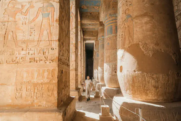 Young Caucasian woman walking in the ancient Egyptian temple in Luxor