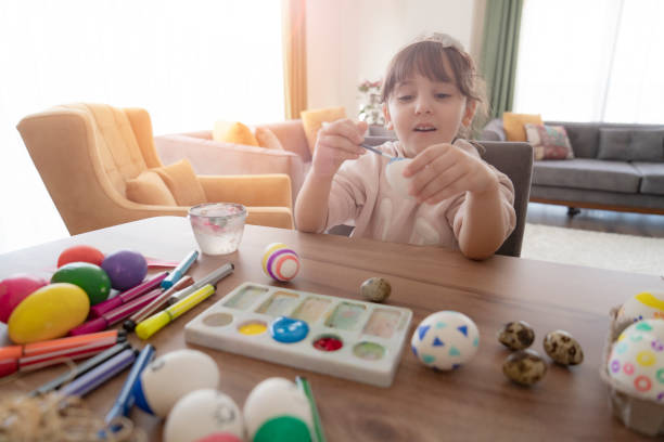 istock Little girl painting Easter egg 1305828353