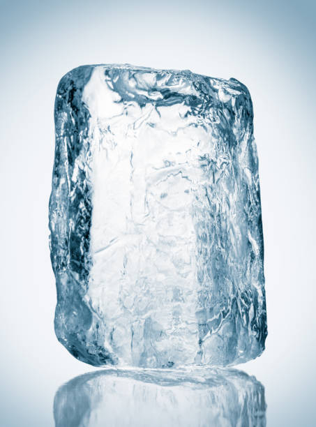 istock Block of textured clear blue ice on a reflective surface. Clipping path included. 1305831281