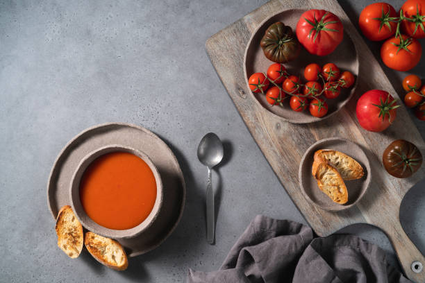 tomatensuppe auf schüssel und zutaten auf grauem hintergrund - tomato soup red basil table stock-fotos und bilder