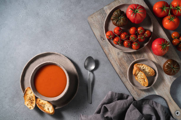 zuppa di pomodoro su ciotola e ingredienti su sfondo grigio - gazpacho salsa vegan food freshness foto e immagini stock