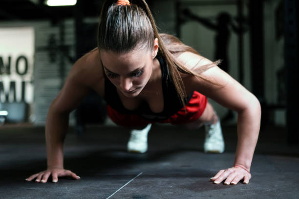 istock Young woman exercising and doing push-ups indoors 1305831460