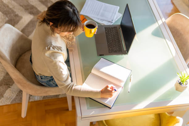 istock Hard Working Young beautiful Woman is writing and using laptop. She is working from home office 1305835747