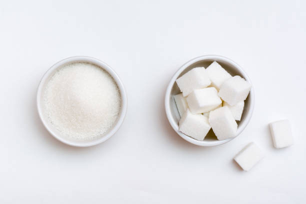 istock Choice between granulated sugar and sugar cubes in bowls on a white background. Top view 1305837194