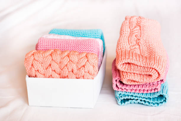 istock Organization and order. A stack of knitted clothes next to a box of neatly folded items 1305838106