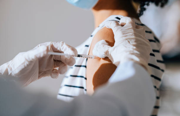 istock Immunisation Process: Nurse Injecting a Patient With a Jab in Her Arm 1305839579