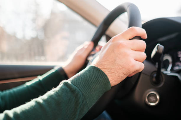 istock Close up mans hands on the wheel, driving a car. 1305839947