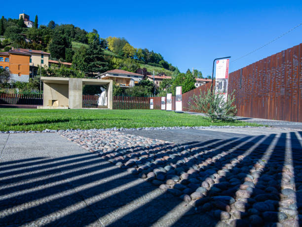 estatua del papa juan veintitrés y las planchas de hierro donde los fieles fijan los imanes - architecture bergamo blue building exterior fotografías e imágenes de stock